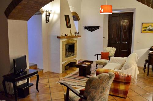 een woonkamer met een bank en een open haard bij Casa do Avô Zezinho in Monsaraz