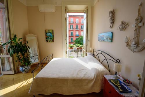 ナポリにあるAppartamento Panoramico "Il Glicine"のベッドルーム(白いベッド1台、窓付)