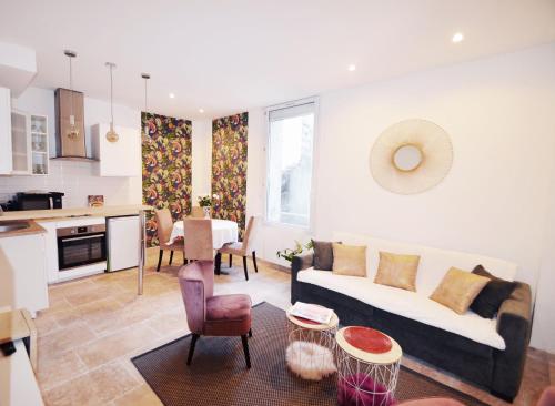 un salon avec un canapé et une table et une cuisine dans l'établissement T2 Montpellier centre historique, à Montpellier