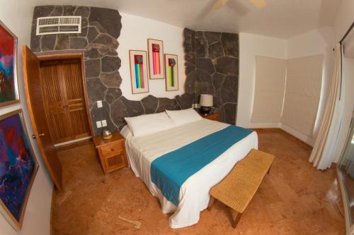 a bedroom with a bed and a stone wall at Mi Otra Casa in Sayulita