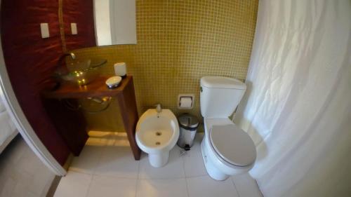 a small bathroom with a toilet and a sink at Complejo Oceanico in Punta Del Diablo