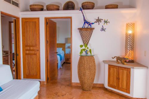 a room with a bed and a vase on the wall at Mi Otra Casa in Sayulita