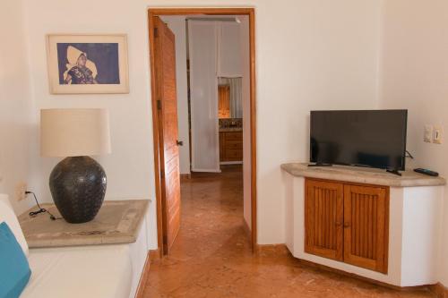a living room with a flat screen tv on a cabinet at Mi Otra Casa in Sayulita