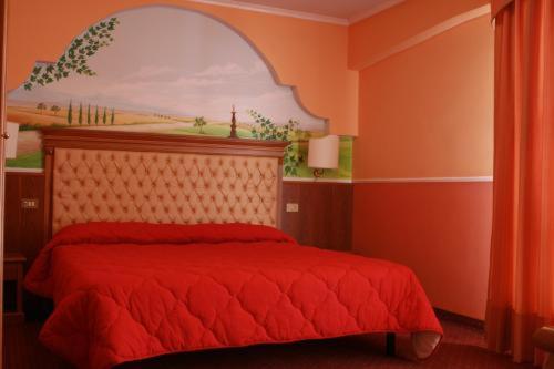 Un dormitorio con una cama roja con una pintura en la pared en MARCHESINA RESORT srls, en Teggiano