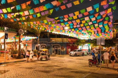 a group of people walking around a street at night at Mi Otra Casa in Sayulita