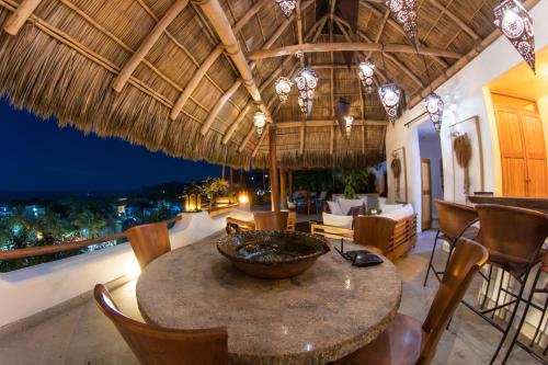a dining room with a table and chairs on a balcony at Mi Otra Casa in Sayulita