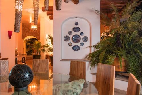 a dining room with a glass table and plates on the wall at Mi Otra Casa in Sayulita