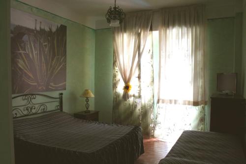 a bedroom with two beds and a window at Hotel 5 Terre Nel Sole in Deiva Marina