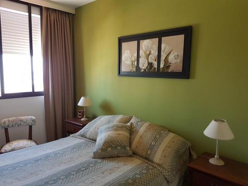 1 dormitorio con 1 cama y una foto en la pared en Luminoso Apartamento en Aidy Grill, en Punta del Este