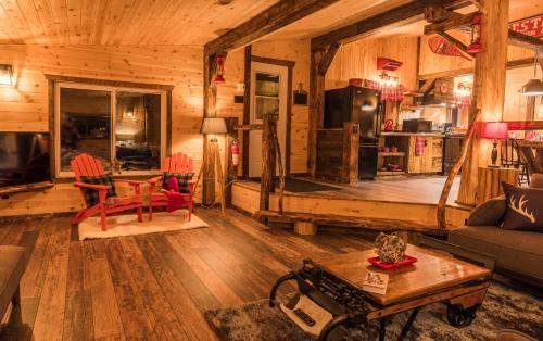 a living room with a couch and a table at Le Trappeur - Les Chalets Spa Canada in La Malbaie