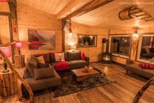 a living room with couches and a fireplace in a cabin at Le Trappeur - Les Chalets Spa Canada in La Malbaie