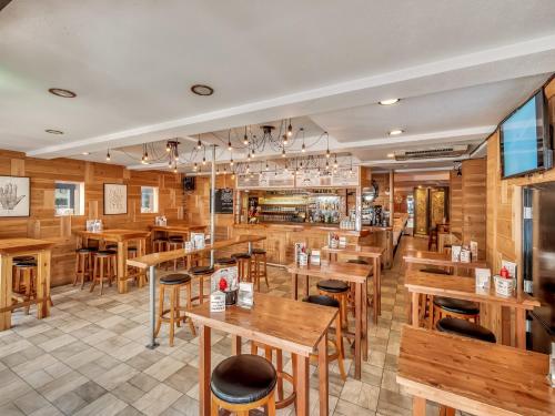 a restaurant with wooden walls and tables and chairs at Hakuba Gondola Hotel in Hakuba