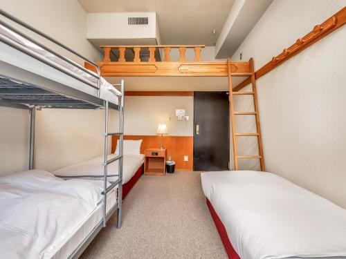 a bedroom with two bunk beds and a desk at Hakuba Gondola Hotel in Hakuba