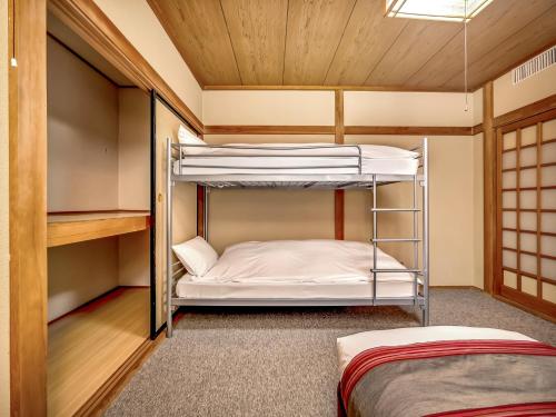 two bunk beds in a room with wooden ceilings at Hakuba Gondola Hotel in Hakuba