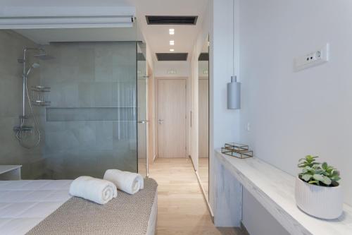 a bathroom with a shower and a bench with towels at Villa Nissos in Líndos