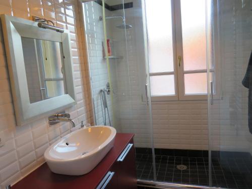ein Bad mit einem Waschbecken und einer Glasdusche in der Unterkunft Emozione Bologna Sant Orsola in Bologna