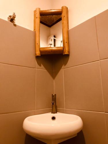 a bathroom with a sink and a mirror on the wall at Everyday Sunday Hotel & Cafe in Bantayan Island