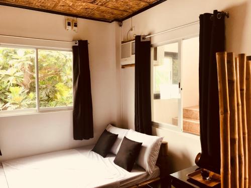 a room with a bed with a window and a couch at Everyday Sunday Hotel & Cafe in Bantayan Island