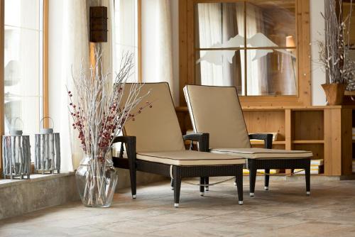 two chairs and a vase with flowers in a room at Alpenresort Fluchthorn in Galtür