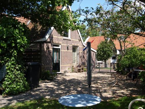 a brick house with a sign in the yard at De iisfugel in Gaast