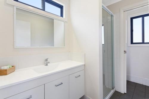 a white bathroom with a sink and a shower at Goulburn South Caravan Park in Goulburn