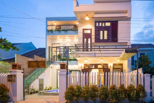 a house with a white fence in front of it at Le Printemps d' An Bang in Hoi An