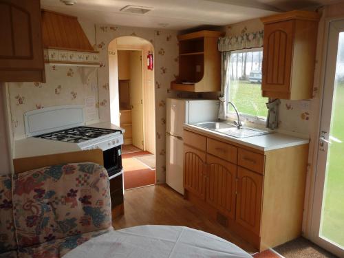 a small kitchen with a sink and a stove at Camping u Kukačků in Horní Planá
