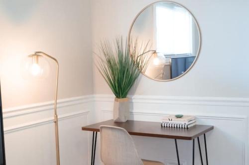 a table with a mirror and a chair and a lamp at Calm & Well-Equipped 2BR Chicago Apartment - Central Cozy in Dunning