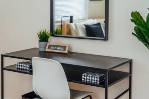 a desk with a white chair in front of a mirror at Calm & Well-Equipped 2BR Chicago Apartment - Central Cozy in Dunning