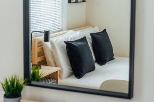 a mirror reflecting a bed with pillows on it at Calm & Well-Equipped 2BR Chicago Apartment - Central Cozy in Dunning