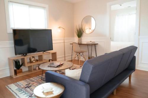 a living room with a blue couch and a tv at Calm & Well-Equipped 2BR Chicago Apartment - Central Cozy in Dunning