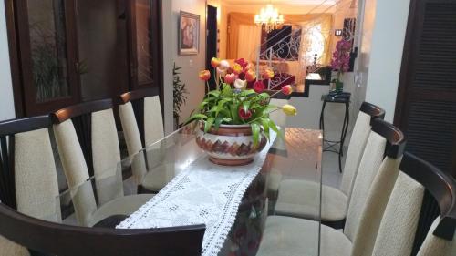 a glass table with a vase of flowers on it at Pousada da Paz in Curitiba