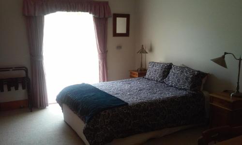 a bedroom with a bed and a large window at Marinavisage in Kettering