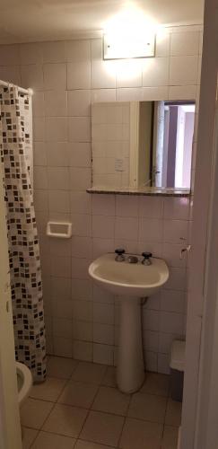 a bathroom with a sink and a mirror and a toilet at Hotel Positano in Mar del Plata