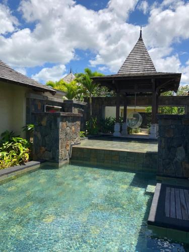 a swimming pool in a house with a gazebo at Villa Calypso in Bel Ombre