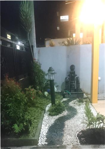 a garden with a lantern in the middle of a yard at Villa Rafif Batu - Four Bedroom in Batu