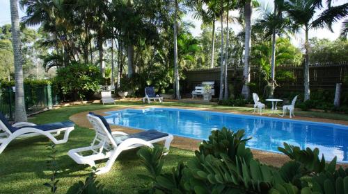 a swimming pool with two chairs and a table at Cleveland Motor Inn in Cleveland