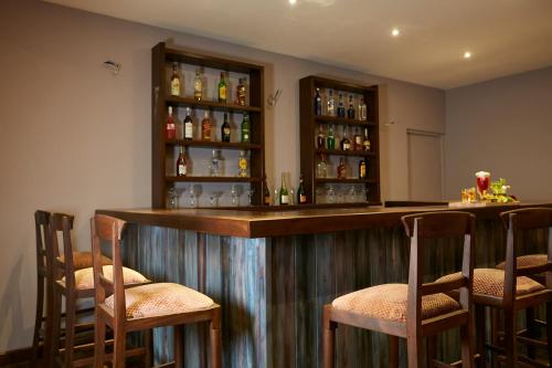 a bar in a room with chairs and bottles at Galway Heights Hotel in Nuwara Eliya