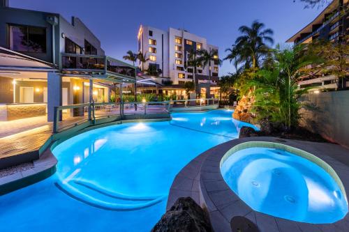 a large swimming pool in a resort at night at View Brisbane in Brisbane