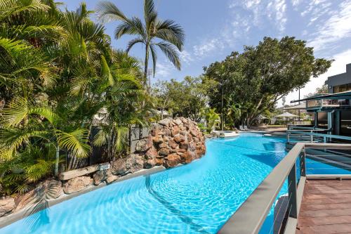 a pool at a resort with palm trees at View Brisbane in Brisbane