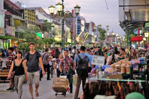 a crowd of people walking down a busy city street at KHAS Malioboro Hotel in Yogyakarta
