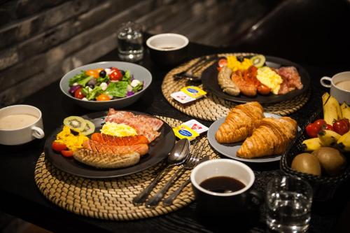 una mesa con platos de comida para el desayuno. en Amare, en Suwon