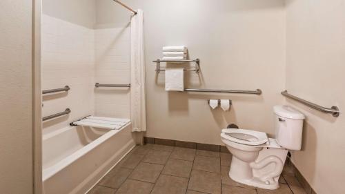 a bathroom with a toilet and a bath tub at Best Western Jacksonville Inn in Jacksonville