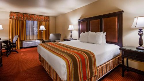 een hotelkamer met een groot bed en een bureau bij Best Western San Isidro Inn in Laredo