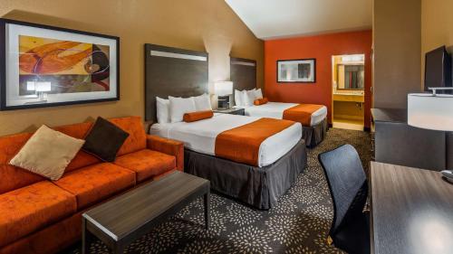 a hotel room with two beds and a couch at Best Western Executive Inn El Campo in El Campo