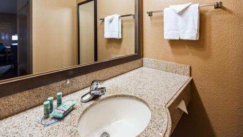 a bathroom with a sink and a mirror at Best Western Executive Inn El Campo in El Campo