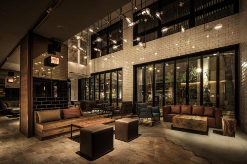 a lobby with couches and chairs in a building at Nest Hotel Osaka Umeda in Osaka