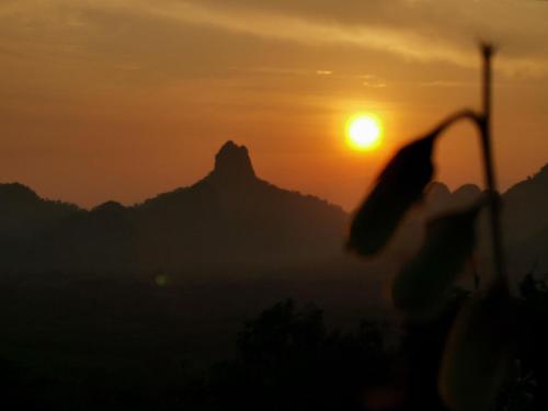 a sunset with the mountains in the background at Por Sampao Camp&Resort in Ban Pha Saeng Lang