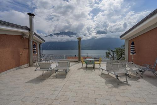 a patio with chairs and a table with a view of the water at Hotel Riviera Panoramic Green Resort in Limone sul Garda