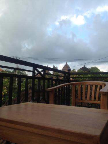 a wooden table on a balcony with a view of the ocean at Wina Ubud B&B in Ubud